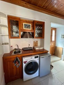a kitchen with a washing machine and a sink at HYDRA Central House in Hydra
