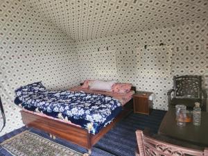 a small bedroom with a bed and a table at New Kufari Apple Valley camping in Shimla