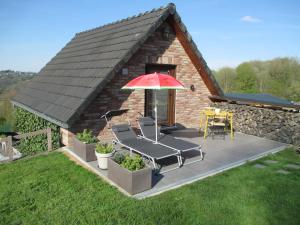 a patio with an umbrella and a table and chairs at " Al'Coppette " Gîte open-space in Comblain-au-Pont