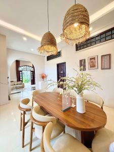 a dining room with a wooden table and chairs at K'TY Homestay Phan Thiết in Ấp Bình Hưng