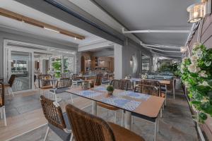a restaurant with tables and chairs in a restaurant at Ouzas luxury Hotel in Olympic Beach