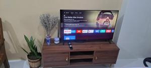 a flat screen tv sitting on a wooden stand at Brenthill Condo Quartz unit in Baguio +6 photos
