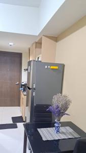 a kitchen with a refrigerator and a vase of flowers on a table at Brenthill Condo Quartz unit in Baguio