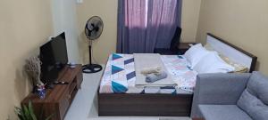 a bedroom with a bed with a chair and a dresser at Brenthill Condo Quartz unit in Baguio