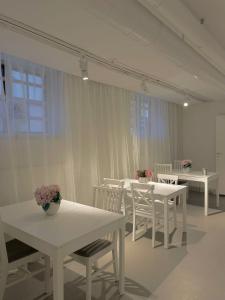 a white dining room with white tables and white chairs at Kville Hostel in Gothenburg