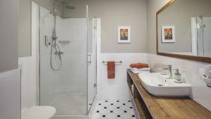 a white bathroom with a shower and a sink at SeNo6 Apartments in Prague +36 photos