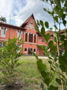 a large red building with a grass field in front of it at Hotel Valenciano in Valença