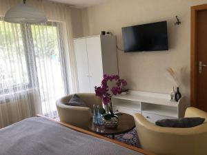 a living room with a bed and a tv on the wall at Haus Milaneva in Klotten