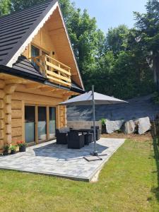 a wooden cabin with a picnic table and an umbrella at Potokowe Zacisze in Zakopane