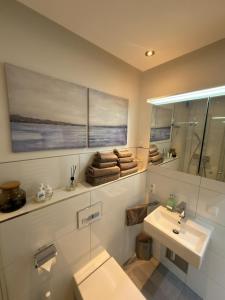 a bathroom with a sink and a toilet and a mirror at Moderne Wohnung - ULM Stadtmitte in Ulm