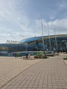 a large stadium with people sitting in front of it at Green apple in Almaty