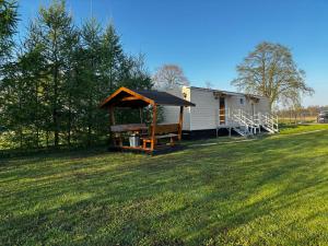 a mobile home with a gazebo in a field at Agroturystyka Kameralna93 in Ochaby