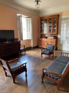 a living room with furniture and a flat screen tv at Hotel Valenciano in Valença