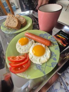 two plates of eggs and tomatoes and bread on a table at Green apple in Almaty