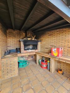an outdoor patio with a brick fireplace and a table at Villa Dourada in Porto Santo