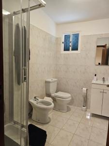a bathroom with a toilet and a glass shower at Villa Dourada in Porto Santo +20 photos