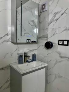 a white bathroom with a sink and a mirror at Fes Golf Residence in Fez +16 photos