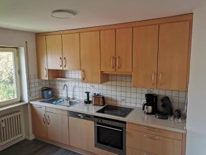 a kitchen with wooden cabinets and a stove top oven at Ferienwohnung KönigSonne in Lauda-Königshofen +4 photos