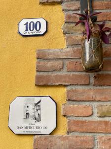 a sign on a brick wall with a plant in a vase at Dimora San Mercurio 100 in Campobasso