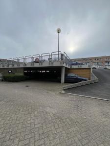 a bridge over a parking lot with a car under it at Ejon in Lelystad