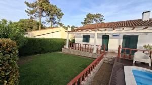 a backyard with a pool and a house at Vivenda Prazeres in Sesimbra