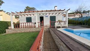 a house with a swimming pool and a fence at Vivenda Prazeres in Sesimbra +6 photos