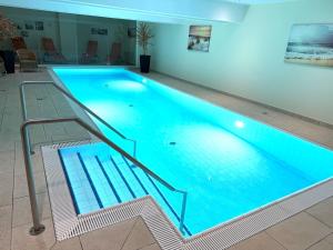 ein großes Schwimmbecken mit blauem Wasser in der Unterkunft Südwind Apartment Nr 05 - FeWo Usedom, strandnah, Schwimmbad, Sauna, Parkplatz, WLAN, und Balkon in Zempin