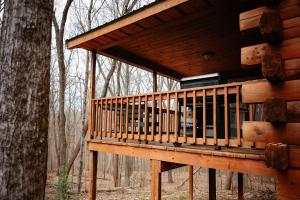 a deck of a log cabin in the woods at Jack Pine Hollow in Logan