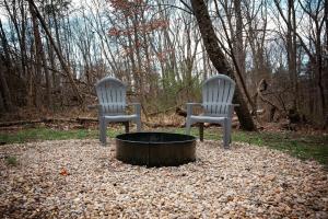 two chairs sitting in front of a fire pit at Jack Pine Hollow in Logan