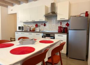a kitchen with a white table and a refrigerator at FLO Homestay in Levico Terme