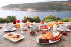 a table topped with plates of breakfast foods and orange juice at Panorama Rooms in Pyrgos Dirou +46 photos