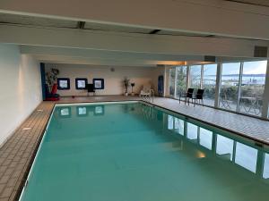 a large swimming pool with blue water in a building at Panoramaudsigt og swimmingpool midt i Ebeltoft in Ebeltoft