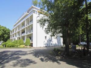 ein weißes Gebäude mit einem Baum davor in der Unterkunft Südwind Apartment Nr 05 - FeWo Usedom, strandnah, Schwimmbad, Sauna, Parkplatz, WLAN, und Balkon in Zempin