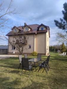 a table and chairs in front of a house at Ostoja Jaczno in Smolniki
