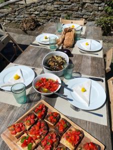 a wooden table topped with plates and bowls of food at Relax alpino con sauna - Ca da Viola in Cavagnago +28 photos