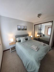 a bedroom with a large bed and a large mirror at Quholmslie Farm Self-Catering in Stromness