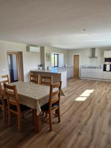 a kitchen and living room with a table and chairs at Quholmslie Farm Self-Catering in Stromness