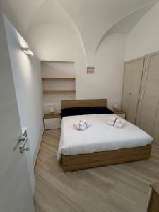 a bedroom with a bed with two towels on it at Dimora Piazza Palazzo in LʼAquila