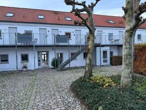 a large white building with a staircase in a courtyard at Panoramaudsigt og swimmingpool midt i Ebeltoft in Ebeltoft