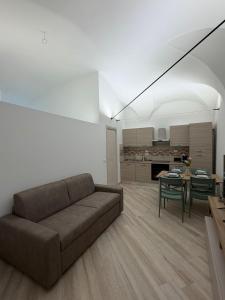 a living room with a couch and a table at Dimora Piazza Palazzo in LʼAquila