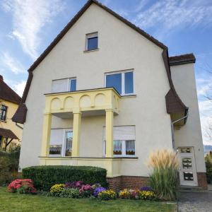 a white house with some flowers in the yard at StayKassel Apartment in Kassel