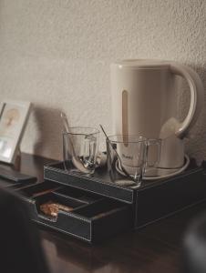 ein schwarzes Tablett mit Tassen und einem Kaffeebecher in der Unterkunft Hotel Chantereyne in Cherbourg en Cotentin