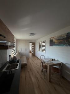 a kitchen and living room with a table and a couch at Domek na łowisku in Adamówka