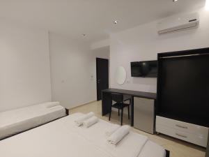 a bedroom with two beds and a desk and a television at Villa LeoZeka in Ksamil