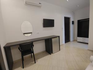 a desk with a mirror and a chair in a room at Villa LeoZeka in Ksamil +43 photos
