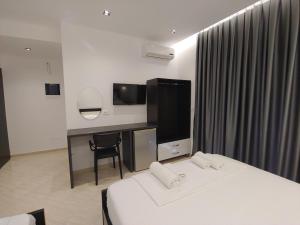 a hotel room with two beds and a television at Villa LeoZeka in Ksamil