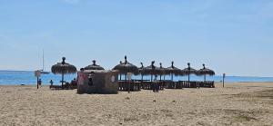 a group of straw umbrellas on a beach at Residencial Colibrí in Cambrils