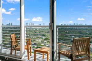 two chairs on a balcony with a view of the city at Hollywood Beach Speakeasy Condo with Pool in Hollywood