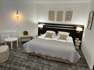 ein Hotelzimmer mit einem großen Bett und einem Tisch in der Unterkunft Hotel Chantereyne in Cherbourg en Cotentin
