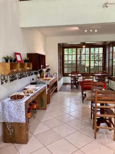 a large kitchen with tables and chairs in a room at Pousada 3 Bacias Penedo in Penedo
